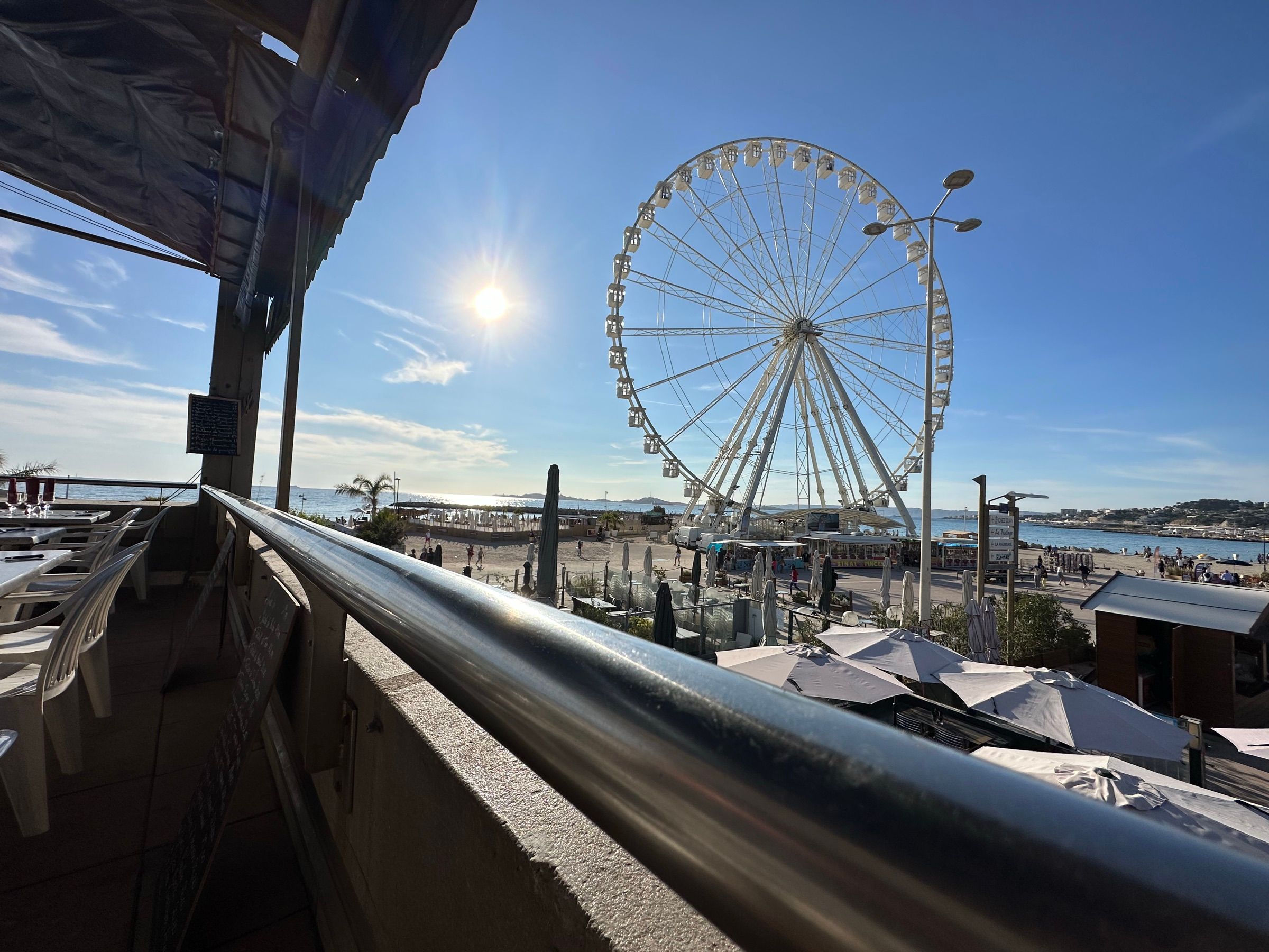 Pogled s restoranske terase na plažu i panoramski kotač